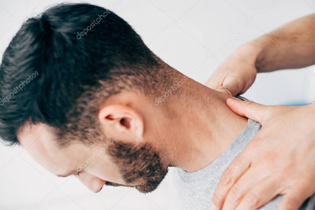 Cropped view of doctor massaging patient neck in massage cabinet at clinic