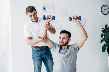 Hastanede dambıl tutan hasta chiropractor masaj kolu