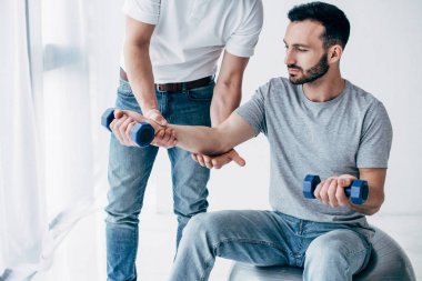 Hastanede Dambıl ile yakışıklı hastanın kolu germe chiropractor
