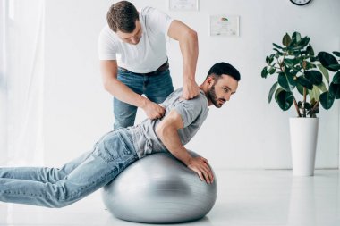 chiropractor hastane içinde fitness topu yatan adam geri Masaj