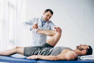 Hastanede hastanın bacak Germe yakışıklı chiropractor