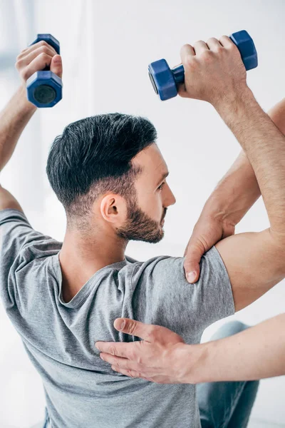 Chiropractor Massaging Arm Handsome Patient Holding Dumbbells Hospital — Stock Photo, Image