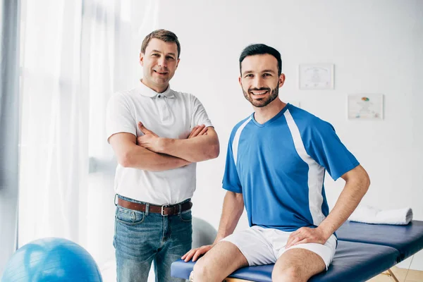 Sonriente Fisioterapeuta Jugador Fútbol Hospital Mirando Cámara —  Fotos de Stock