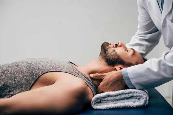 Quiroprático Massageando Pescoço Homem Bonito Deitado Mesa Massagem Cinza — Fotografia de Stock