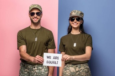 biz eşit tir ile kağıt tutan askeri üniformalı mutlu erkek ve kadın! mavi ve pembe üzerine yazı