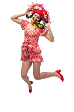 girl in festive clothes and Straw Hat biting sunflower and jumping Isolated On White clipart