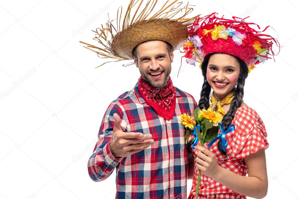 cheerful man and young woman in festive clothes with sunflowers isolated on white