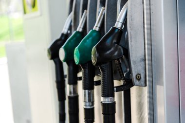 selective focus of green and black fuel pumps at gas station  clipart