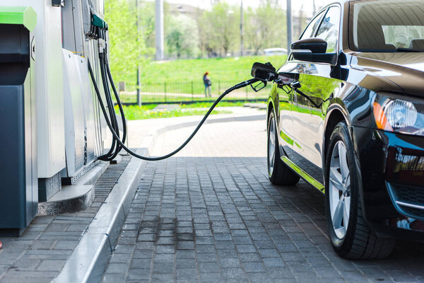black modern car refueling with benzine on gas station 