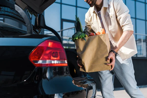 Vista Ritagliata Uomo Barbuto Mettendo Sacchetto Carta Nel Bagagliaio Auto — Foto Stock