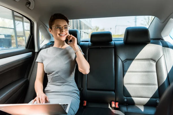 Mujer Negocios Feliz Gafas Hablando Teléfono Inteligente Mientras Utiliza Ordenador — Foto de Stock