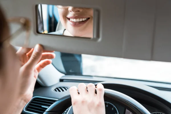 Περικομμένη Θέα Της Χαμογελαστή Γυναίκα Κοιτάζοντας Καθρέφτη Στο Αυτοκίνητο — Φωτογραφία Αρχείου