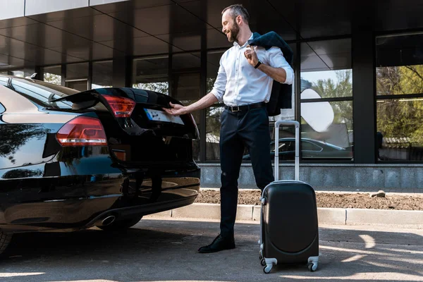 Visão Baixo Ângulo Feliz Empresário Abrir Porta Malas Carro Enquanto — Fotografia de Stock