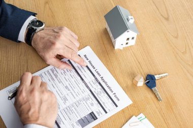 ev modeli ve anahtar yakın yeni ev kredisi başvuru formu yakınında kalem tutan ev bayisi kırpılmış görünümü