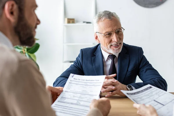 Lycklig Bilåterförsäljare Glas Sitter Med Knuten Händer Nära Kunder Med — Stockfoto