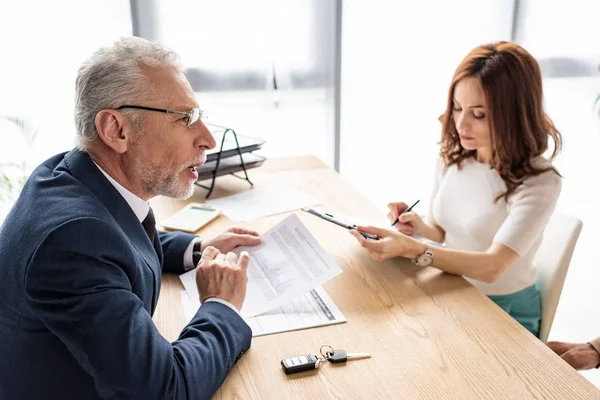 Autodealer Glazen Kijken Naar Aantrekkelijke Vrouw Met Klembord Pen — Stockfoto