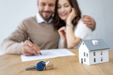 neşeli kadın ve erkek yakın tuşları ve ev modeli seçici odak 