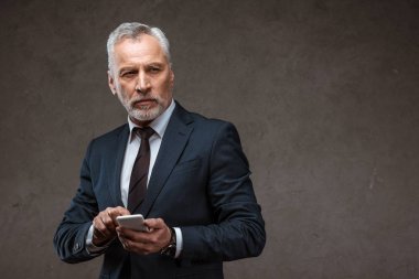 gri akıllı telefon tutan başarılı sakallı işadamı 
