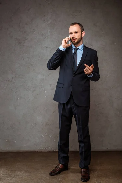 Hombre Negocios Guapo Hablando Teléfono Inteligente Señalando Con Dedo Gris — Foto de Stock