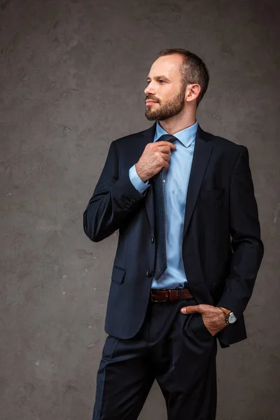 Schöner Geschäftsmann Mit Der Hand Der Tasche Und Anrührender Krawatte — Stockfoto