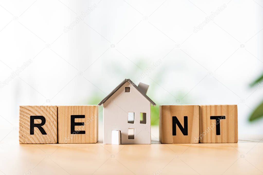 house model near wooden cubes with rent lettering on table