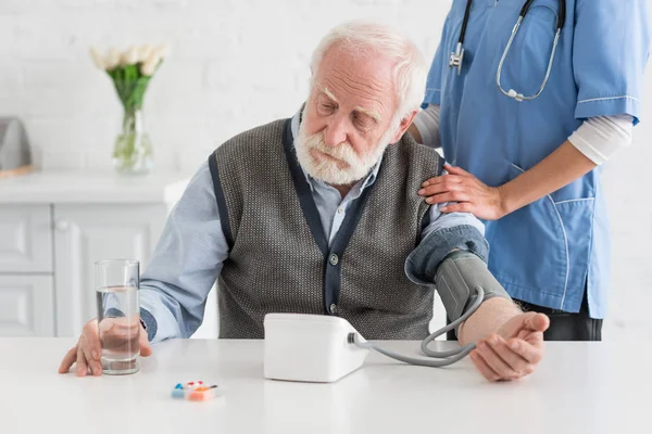 Enfermeira Medir Pressão Arterial Homem Cabelos Grisalhos Calmos — Fotografia de Stock