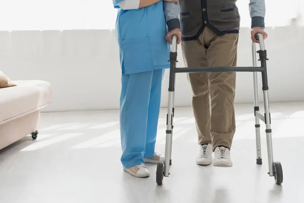 Vista Recortada Enfermera Caminando Con Hombre Mayor Habitación Luminosa —  Fotos de Stock