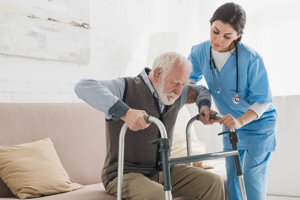 Médico Ajudando Homem Aposentado Levantando Sofá — Fotografia de Stock