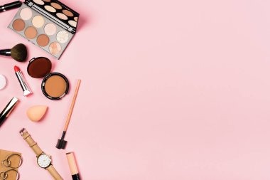 kol saati, küpe ve pembe dekoratif kozmetik üst görünümü