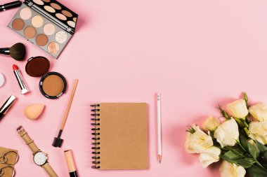 kol saati, küpe, çiçek, defter, kalem ve pembe dekoratif kozmetik üst görünümü