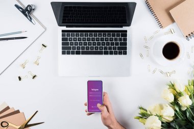 Kiev, Ukrayna - 11 Mayıs 2019: işyerinde ekranda instagram uygulaması ile akıllı telefon tutan adamın kırpılmış görünümü