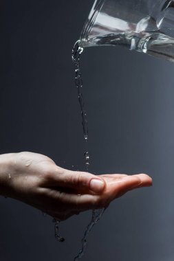 sürahi ve karanlık üzerinde akan su ile kadının kırpılmış görünümü