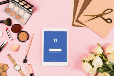 Kiev, Ukrayna - 11 Mayıs 2019: ekranda facebook uygulaması ile dijital tablet üst görünümü, çiçekler, aksesuarlar, dekoratif kozmetik, makas ve pembe kağıtları