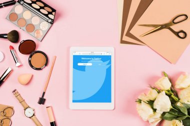 Kiev, Ukrayna - 11 Mayıs 2019: ekranda twitter uygulaması ile dijital tablet üst görünümü, dekoratif kozmetik, çiçek, zanaat kağıt ve pembe makas
