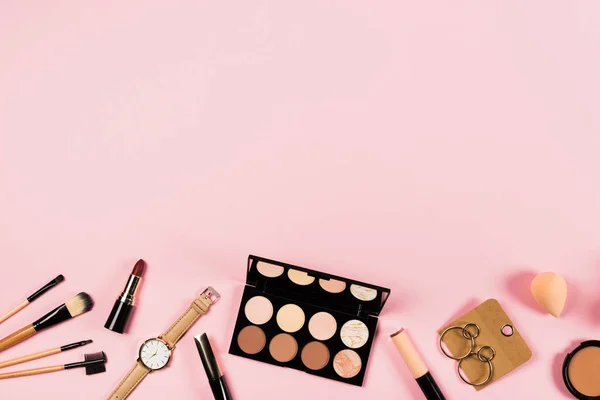 Top view of wristwatch, earrings and decorative cosmetics on pink — Stock Image Top View Wristwatch Earrings Decorative Cosmetics Pink Stock Picture