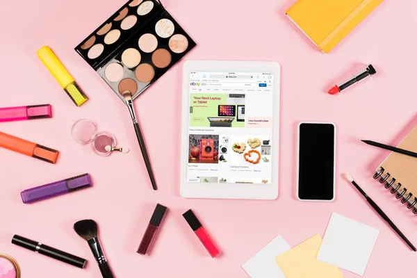 Top view of digital tablet with ebay app on screen, smartphone with blank screen, highlighters and decorative cosmetics on pink — Stock Image Top View Digital Tablet Ebay App Screen Smartphone Blank Screen Royalty Free Stock Photos