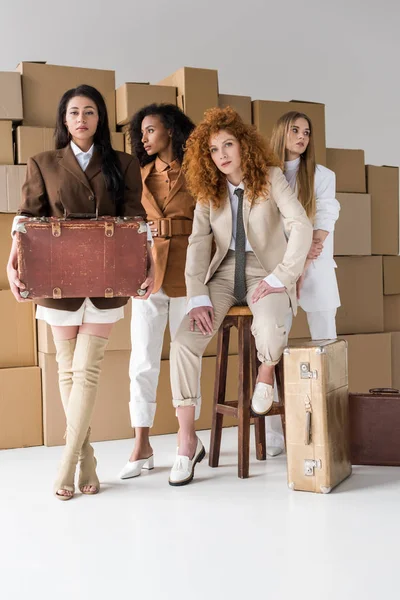 Güzel Çok Kültürlü Kızlar Beyaz Kutular Yanında Bavul Ile Ayakta — Stok fotoğraf