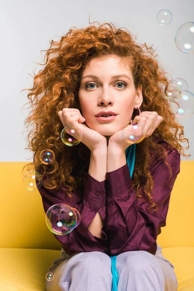 Attractive Curly Redhead Woman Looking Camera Touching Face Soap Bubbles Royalty Free Stock Photos