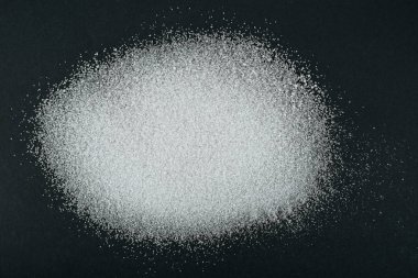 top view of white granulated sugar crystals on black background clipart