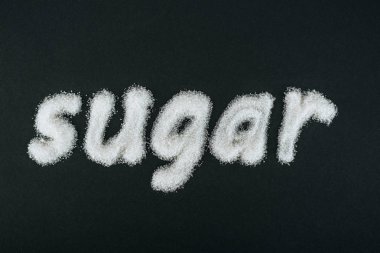 topi view of word sugar made of white sugar crystals on black background clipart