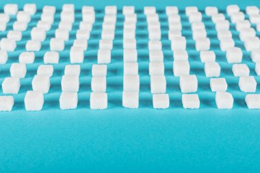 white sugar on blue surface arranged in horizontal rows clipart