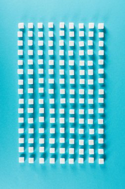 top view of white sugar cubes arranged in rows on blue surface clipart