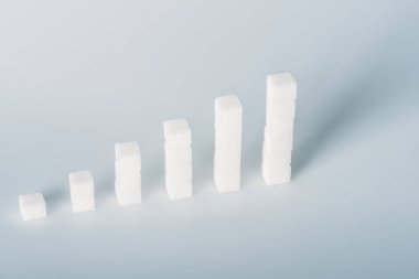white sugar cubes arranged in stacks on grey background with copy space clipart