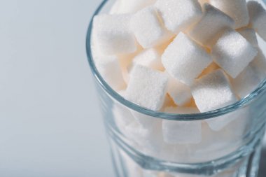 close up view of white sugar cubes in glass on grey background  clipart
