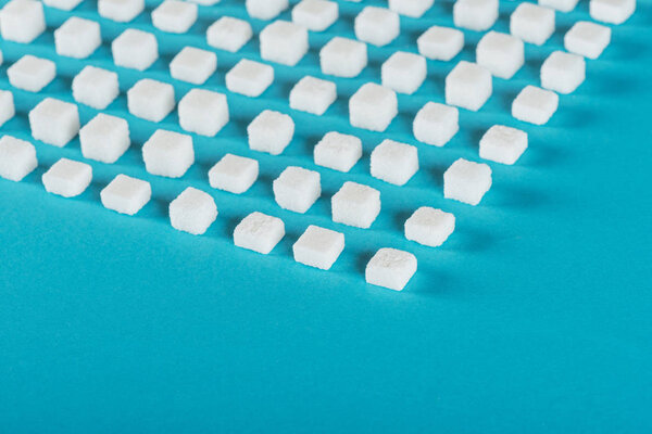 white sugar cubes arranged in rows on blue surface