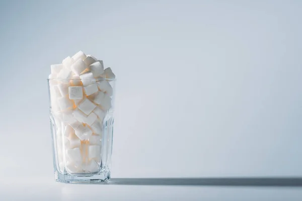 Vaso Lleno Cubos Azúcar Blanco Refinado Sobre Fondo Gris Con — Foto de Stock