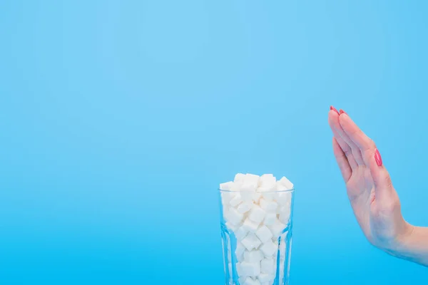 Vista Cortada Mulher Recusando Cubos Açúcar Branco Vidro Isolado Azul — Fotografia de Stock