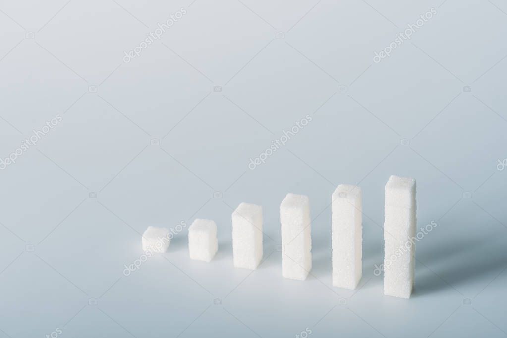 Stacks of white sugar cubes on grey background with copy space stock vector