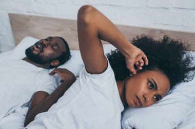 horlama kocası yakınında yatarken parmak la kulak tıkanan Afrikalı Amerikalı kadının seçici odak