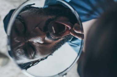 diş ağrısı muzdarip iken aynaya bakan afrikalı amerikalı adam